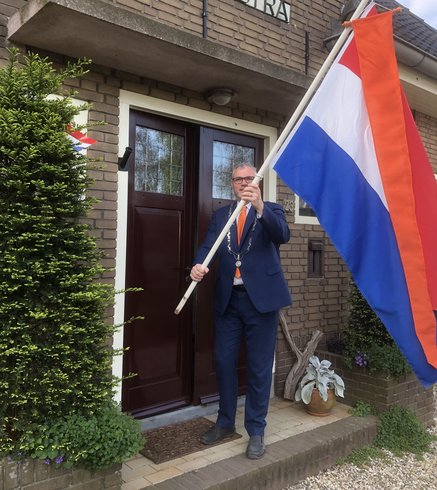 Burgemeester Kottelenberg houdt de Nederlandse vlag omhoog