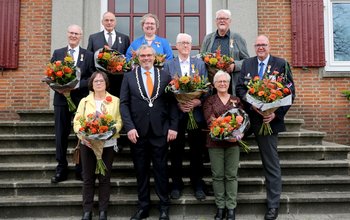 De koning poseert met de gedecoreerden voor het gemeentehuis in Opheusden.