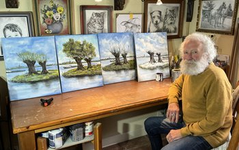 Jelier Vervloed bij de schilderijen voor de senioren huisbezoeken