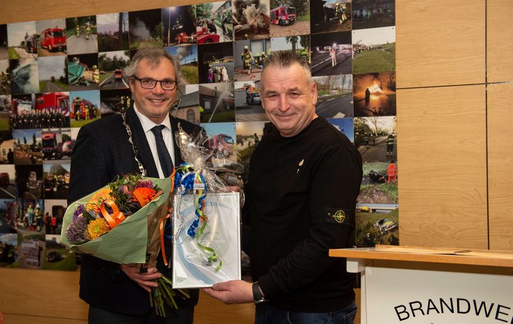 Burgemeester Jan Kottelenberg overhandigt bloemen en de Neder-Betuwe Speld aan Peter Jansen