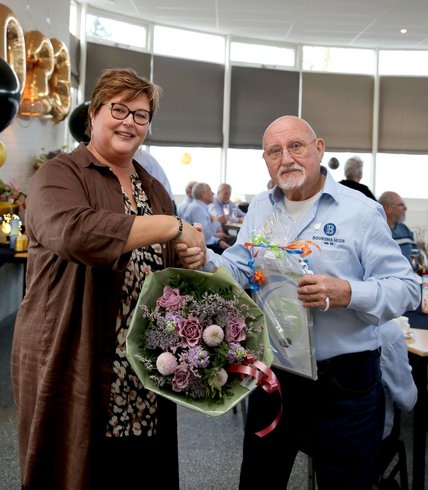 Peter van de Peppel met een boeket bloemen en wethouder Herma van Dijkhuizen