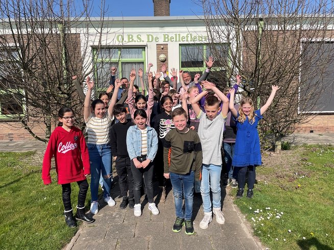 Wethouder Stefan van Someren en kinderen van basisschool Bellefleur voor het schoolgebouw bij de officiële start van de de wedstrijd E-waste Race 2022. 