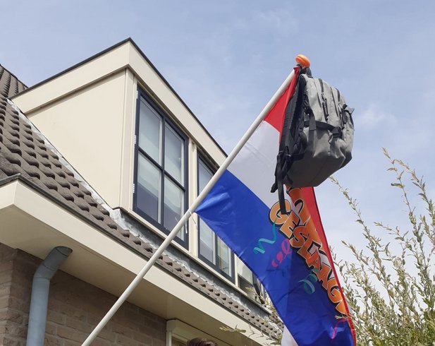 Nederlandse vlag met schooltas in top